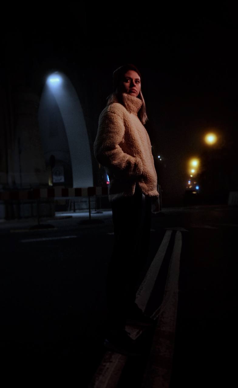 Night street portrait — standing beneath a viaduct arch
